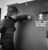 ドイツ南部のナチス・ドイツのダッハウ強制収容所で、ガス室のドアを見る米兵（1945年4月29日撮影）。(c)ERIC SCHWAB / AFP