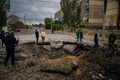 ウクライナ・ドニプロで、ロシアのミサイル攻撃でできた穴を見る住民（2022年10月10日撮影）。(c)Dimitar DILKOFF / AFP