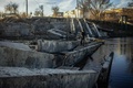 ウクライナ東部ドネツク州バフムートで、崩壊した橋を渡る住民（2022年11月29日撮影）。(c)Yevhen TITOV / AFP