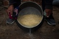 ペルーの首都リマ南郊のパチャクテクの無料食堂でパスタのゆで汁を捨てる様子（2022年4月14日撮影）。(c)Ernesto BENAVIDES / AFP
