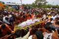 インド・ケララ州カサラゴドで、ワニ「バビア」の死骸を運ぶ人々（2022年10月10日撮影）。(c)AFP