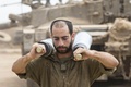 パレスチナ自治区ガザ（Gaza）地区との境界付近のイスラエル軍拠点で、戦車の出撃準備をする兵士（2014年7月25日撮影）。(c)AFP/JACK GUEZ