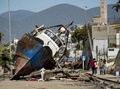 地震に襲われたチリ・コキンボの港で、津波により陸に乗り上げた漁船（2015年9月17日撮影）。(c)AFP/MARTIN BERNETTI