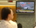 2007年8月20日、台北の銀行のロビーで、那覇空港に着陸後、炎上した中華航空（China Airlines）のニュース速報を見る人。(c)AFP/PATRICK LIN