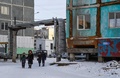 ロシアのシベリア東部ヤクーツクで、ひびが入ったアパートの横を歩く人々（2018年11月26日撮影）。(c)Mladen ANTONOV / AFP