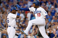13MLBプレーオフ、ナ・リーグ地区シリーズ（5回戦制）、ロサンゼルス・ドジャース（Los Angeles Dodgers）対アトランタ・ブレーブス（Atlanta Braves）第3戦。本塁に生還し、ヤシエル・プイグ（Yasiel Puig、左）とハイタッチを交わすロサンゼルス・ドジャースのヘンリー・ラミレス（Hanley Ramirez、2013年10月6日撮影）。(c)AFP/Getty Images/Stephen Dunn