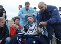カザフスタン・ジェスカズガン近郊の草原に帰還し、ロシア宇宙庁の職員に囲まれるロシア人宇宙飛行士のゲナディ・パダルカ氏（中央、2015年9月12日撮影）。(c)AFP/YURI KOCHETKOV