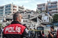 トルコ・イズミルで、倒壊した建物のがれきから生存者を捜索する救助隊員ら（2020年10月30日撮影）。(c)MERT CAKIR / AFP