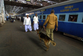 インド・ムンバイ（Mumbai）の駅構内で、警察犬を連れて巡回する私服警官（右、2006年8月24日撮影、資料写真）。(c)AFP
