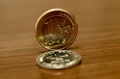 クロアチアの通貨クーナ（下）と欧州連合単一通貨ユーロの硬貨（2022年12月30日撮影）。(c)Denis LOVROVIC / AFP
