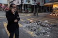 香港の旺角地区で、違法屋台の取り締まりに抗議する人と警官隊が衝突した後、焼け焦げた残骸のそばを歩く男性（2016年2月9日撮影）。(c)AFP/DALE DE LA REY