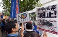 横浜市で開かれた安全保障関連法案に関する地方公聴会の会場前でプラカードを掲げて同法案に抗議する人々（2015年9月16日撮影）。(c)AFP/Yoshikazu TSUNO