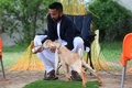 パキスタン南部カラチで、子ヤギのシンバにミルクを飲ませる飼い主のモハマド・ハサン・ナレジョさん（2022年7月6日撮影）。(c)Asif HASSAN / AFP