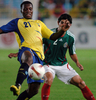 エクアドルのカルロス・テノリオ（%%Carlos Tenorio%%）をマークするメキシコのホニー・マガジョン（%%Jonny Magallon%%）。(c)AFP/GERARDO MORA