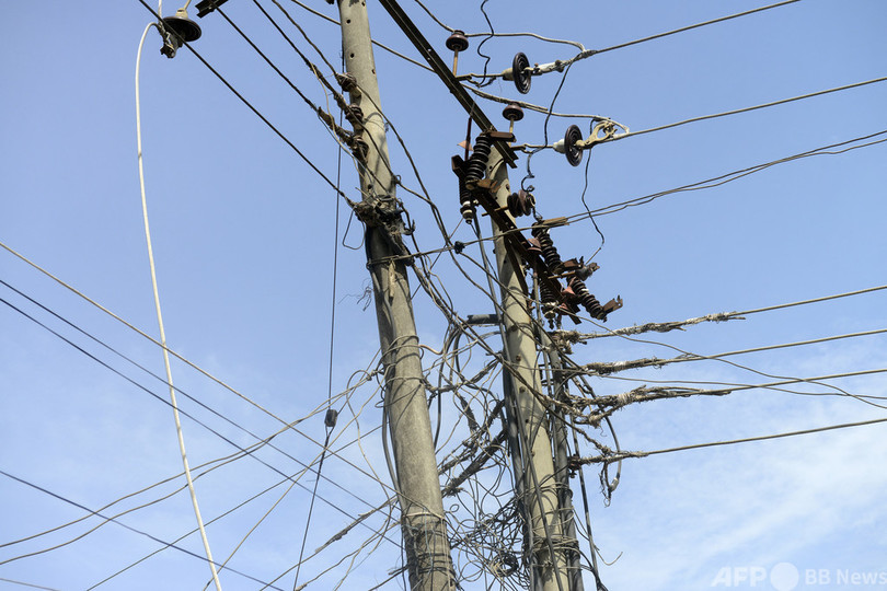電柱の上で筋トレ、数万世帯で停電 中国