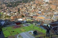 南米コロンビア・メデジン（Medellin）の最貧国地区のひとつ「コムーナ13（Comuna 13）」の建物に絵を描くアーティストたち（2014年4月1日撮影）。(c)AFP/Raul ARBOLEDA