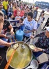 ペルー北部トゥンベスで入国審査待ちの際、ボランティアが配る食事を受け取るベネズエラ人たち（2018年8月23日撮影）。(c)CRIS BOURONCLE / AFP