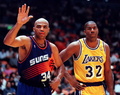 Charles Barkley of the Phoenix Suns waves to fans as Magic Johnson (R) of the Los Angeles Lakers watches during their 14 April game in Inglewood, California. (c)AFP/Vince BUCCI