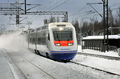 フィンランド・ヘルシンキ（Helsinki）そばの駅を通過する新型高速鉄道「アレグロ（Allegro）」（2010年12月12日撮影）。(c)AFP/Timo Jaakonaho
