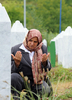 ボスニア・ヘルツェゴビナ東部スレブレニツァ（Srebrenica）の郊外ポトチャリ（Potocari）のスレブレニツァ虐殺犠牲者追悼施設で、親族の墓前で祈るイスラム教徒女性（2008年7月22日撮影）。(c)AFP/ELVIS BARUKCIC