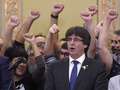 スペイン・カタルーニャ自治州バルセロナで、議会出席後にカタルーニャの歌「収穫人たち」を歌うカルレス・プチデモン州首相（中央）ら（2017年10月27日作成）。(c)AFP/Josep LAGO