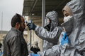 シリアのクルド人自治区で、熱を測る医療従事者（2020年3月1日撮影）。(c)Delil SOULEIMAN / AFP