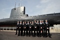 英ゴスポート（Gosport）にある王立海軍潜水艦博物館（Royal Navy Submarine Museum）の港で一般公開された、A級潜水艦「アライアンス（HMS Alliance）号」の前で記念写真を撮影する、英海軍の潜水艦乗組員たち（2014年4月3日撮影）。(c)AFP/GLYN KIRK
