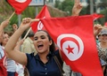 チュニジアの首都チュニス（Tunis）市内で、国旗を掲げて政権退陣を要求するデモ参加者（2013年8月31日撮影）。(c)AFP/SALAH HABIBI