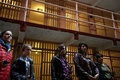 米カリフォルニア（California）州サンフランシスコ（San Francisco）にある悪名高いアルカトラズ島（Alcatraz Island）は21日、島に作られた連邦刑務所の閉鎖から50年を迎えた。アルカトラズ島は当初、軍事要塞化され、やがて軍刑務所となった。施設は1934年に連邦刑務所局（Bureau of Prisons）に移管されて連邦刑務所となった後、1963年に閉鎖された。現在は国立公園の一部となっている。

アルカトラズ島を管理する国立公園局（National Park Service）では、閉鎖50年を記念して、閉鎖される直前の刑務所を撮影した写真展を同島で開催している。写真はいずれもロサンゼルス（Los Angeles）を中心に活動していたフリーカメラマン、リー・ウィーナー（Leigh Wiener）氏が撮影したもので、新たに見つかった作品という。

写真は、旧アルカトラズ刑務所の内部を見て歩く観光客（2013年3月21日撮影）。(c)AFP/Getty Images/Justin Sullivan