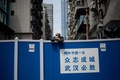 中国・武漢でバリケードの上から顔を出す男性（2020年4月14日撮影、資料写真）。(c)NOEL CELIS / AFP