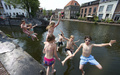オランダ・スキーダム（Schiedam）のスヒー（Schie）川に飛び込む地元の子どもたち（2013年7月22日撮影）。(c)AFP/ANP/JERRY LAMPEN