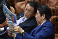 衆院予算委員会で麻生太郎財務相（左）と話す安倍晋三首相（右、2017年2月24日撮影）。(c)AFP/Kazuhiro NOGI