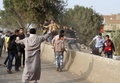 エジプト・ギザ（Giza）にある村で、投票所に向かって石を投げるイスラム組織「ムスリム同胞団（Muslim Brotherhood）」の支持者たち（2014年1月14日撮影）。(c)AFP/KHALED KAMEL