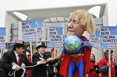 メルケル首相はスーパーマン？ ドイツで環境政策に対する抗議デモ