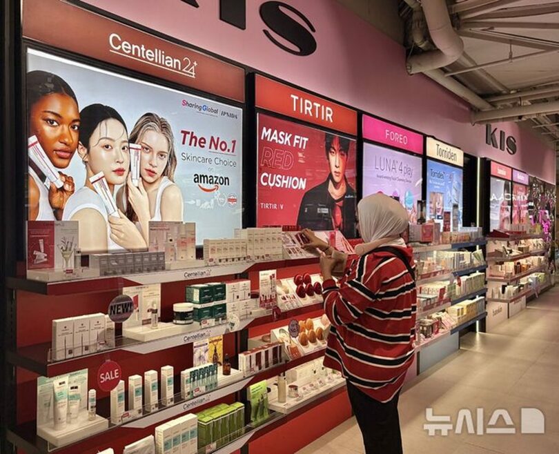 バンコクの商業施設セントラルワールド内の「KISビューティーストア」で、壁面に並ぶ韓国化粧品を見る客＝2026年10月14日(c)NEWSIS
