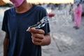 タイ中部ナコンパトム県で開催された大麻の合法化を祝うイベント「タイランド420: リーガルレーオ⁉」で、紙に巻かれた大麻を持つ人（2022年6月11日撮影）。(c)Lillian SUWANRUMPHA / AFP
