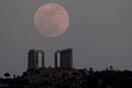 地球と月の距離が年間で最も短くなるタイミングに満月を迎える「スーパームーン（Supermoon）」現象が5日、世界各地で観測された。

楕円（だえん）形の軌道を持つ月には、地球に最も近づく近地点と、地球から最も遠ざかる遠地点がある。スーパームーンは、月がほぼ近地点にあるときに観測される満月のため、地球からは普段よりも14％大きく、30％明るく見える。

写真は、ギリシャ・アテネ（Athens）南方約60キロのスーニオン岬（Cape Sounion）にあるポセイドン（Poseidon）神殿で観測されたスーパームーン（2012年5月5日撮影）。(c)AFP/ARIS MESSINIS