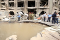 車両を使った自爆攻撃を受けた、イラクの首都バグダッド（Baghdad）中心部の法務省庁舎前にできた穴を見る軍兵士ら（2009年10月25日撮影）。(c)AFP/AHMAD AL-RUBAYE