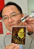 フランソワ・オランド(Francois Hollande)仏大統領をモチーフにした柄の太陽電池の試作品を手にする、東京大学（University of Tokyo）先端科学技術研究センター（Centre for Advanced Science）の瀬川浩司（Hiroshi Segawa）教授（2014年7月24日）。(c)AFP/Yoshikazu TSUNO