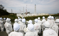 東京電力（TEPCO）は26日、福島第1原子力発電所の敷地内を報道陣に公開した。写真は第1原発を取材する報道陣と東電従業員（2012年5月26日撮影）。(c)AFP/POOL/Tomohiro Ohsumi