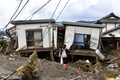 台風19号（アジア名：ハギビス）の影響を受けた長野県で、洪水の被害に見舞われた住宅を見つめる女性（2019年10月15日撮影）。(c)Kazuhiro NOGI / AFP