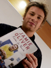 自身の料理本『Cook for Friends』を手にした英人気シェフのジェイミー・オリバー（Jamie Oliver）氏（2004年11月5日撮影）。(c)AFP/ MICHAEL KAPPELER