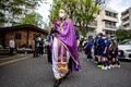 東京都内の教会で行われたウクライナ正教会の「枝の主日」の礼拝で、外を歩く司祭のポール・コロルークさんら（2022年4月17日撮影）。(c)Philip FONG / AFP