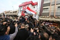 イラクの首都バグダッドで、殺害されたイラン革命防衛隊のガセム・ソレイマニ司令官のひつぎを運ぶ車の周囲に集まった人々（2020年1月4日撮影）。(c)AFP/SABAH ARAR