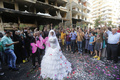 15日に爆弾テロが発生したばかりのベイルート（Beirut）ルワイス（Rweiss）地区で執り行われた結婚式で、参列者たちから祝福される新郎新婦（2013年8月18日撮影）。(c)AFP