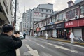 中国・上海の黄浦区で、隔離対象となった住宅街周辺を封鎖する防護服姿の警察官ら（2021年1月21日撮影）。(c)STF / AFP