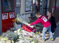 仏南西部モントーバン（Montauban）で、兵士2人が死亡した発砲事件のあった現場に花束を捧げる親子（2012年3月17日撮影）。(c)AFP/PASCAL PAVANI