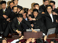 韓国国会で22日、与党ハンナラ党（Grand National Party、GNP）がメディア規制緩和法案を強行採決しようとしたため、与野党議員が国会で乱闘する騒ぎとなった。法案は可決されたが、十数人の負傷者が出た。写真は、議長席を守る警備員ら（2009年7月22日撮影）。(c)AFP/JUNG YEON-JE