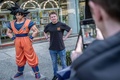 東京都内で、「DRAGON BALL」の主人公、孫悟空の像と同作のTシャツを着て記念撮影をする観光客（2024年3月8日撮影）。(c)Yuichi YAMAZAKI / AFP