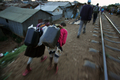 2007年10月23日、ケニヤのスラム街キベラ（Kibera）で、水を入れた容器を持つ女の子たち。(c)AFP/Roberto SCHMIDT